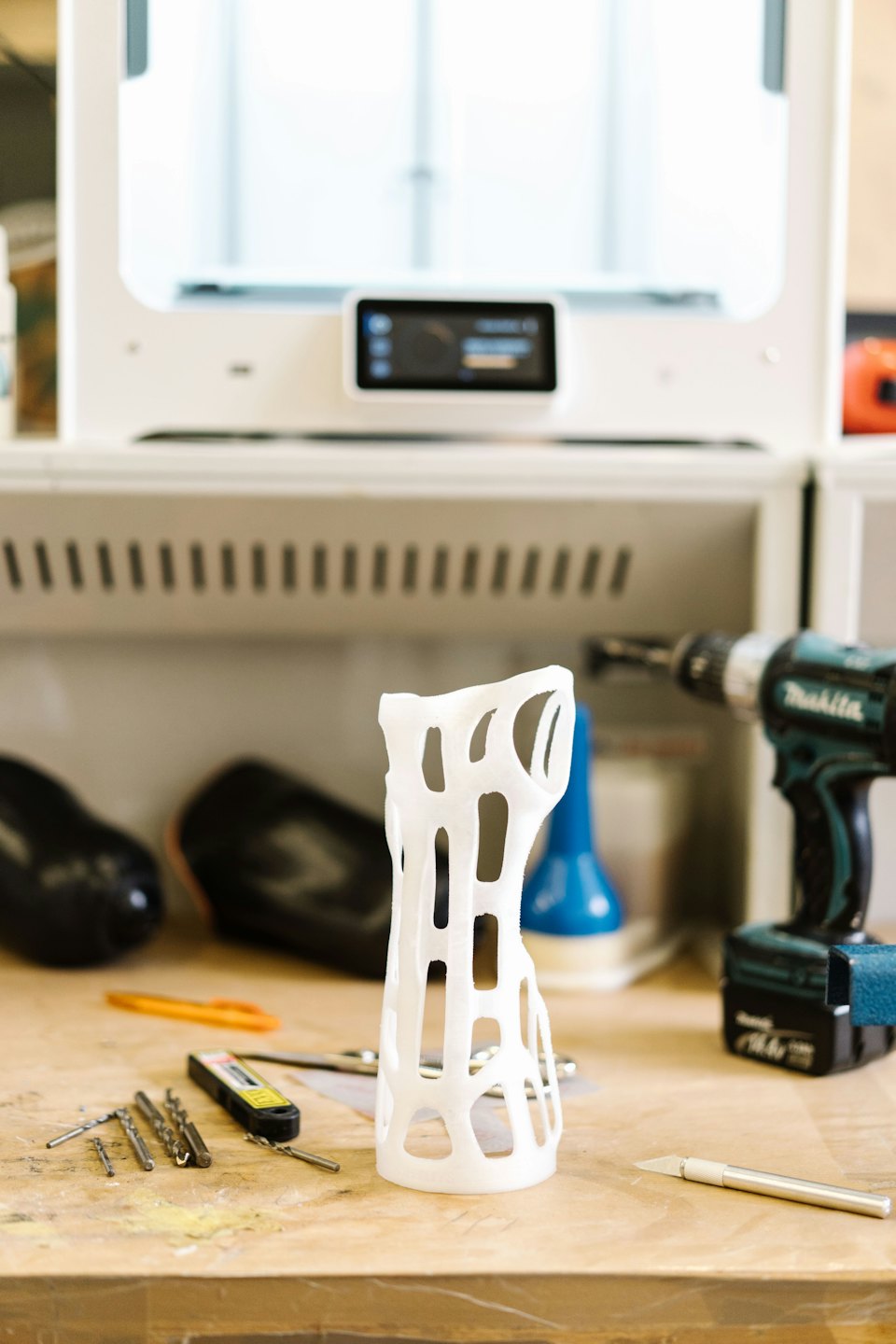 3D printed orthopedic brace on a workbench with tools.
