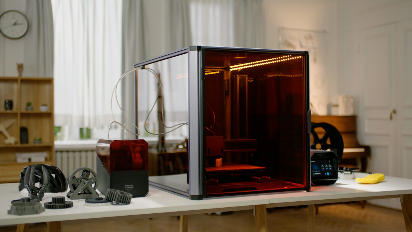 3D printer with printed objects on a white table.